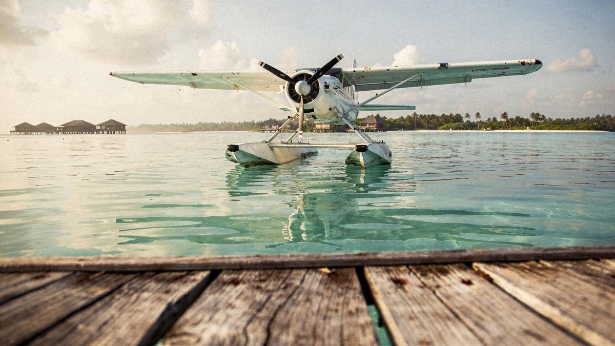 Seaplane pontoon seen at a low angle beside still lagoon water